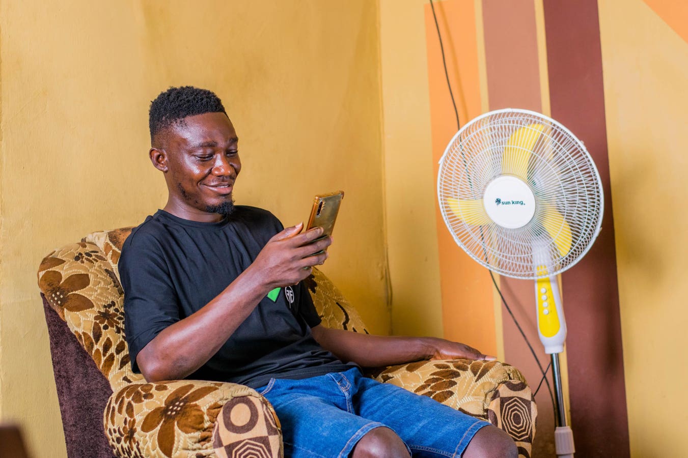 Remote developer in Lagos smiling at phone after instant USDC payroll notification, showcasing cross-border crypto payments in 2025